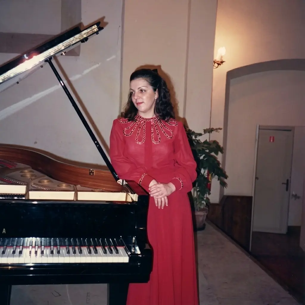 Daniela Donaudi in abito rosso accanto al pianoforte